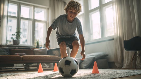 A boy training soccer in his living room.